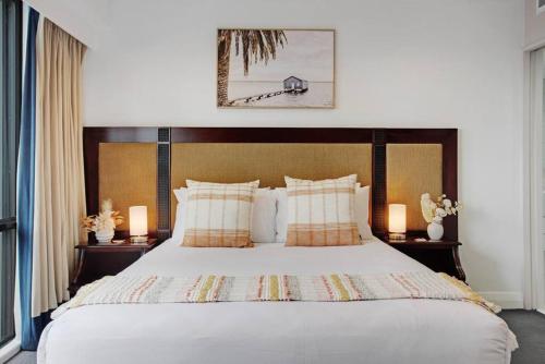 a bedroom with a large bed with two lamps at Luxurious Apt Gym Tennis Carpark 6th Floor in Auckland