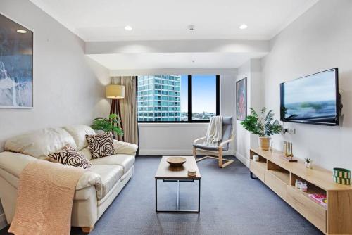 a living room with a couch and a table at Luxurious Apt Gym Tennis Carpark 6th Floor in Auckland