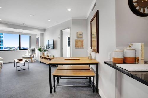 a dining room with a table and a living room at Luxurious Apt Gym Tennis Carpark 6th Floor in Auckland