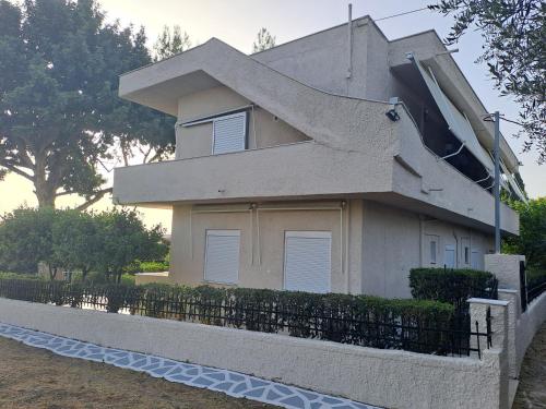 a house with a fence in front of it at Studios Αποστόλης Selianitika in Aígio