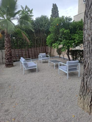 a group of chairs sitting on the ground next to a tree at Studios Αποστόλης Selianitika in Aígio