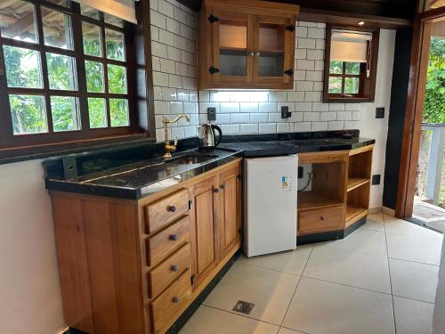 a kitchen with a sink and a refrigerator at Minas Em Marambaia in Rio de Janeiro