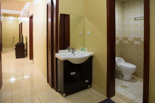 a bathroom with a sink and a toilet at ضيافة بيت المسرة للشقق المخدومة in Al Khobar