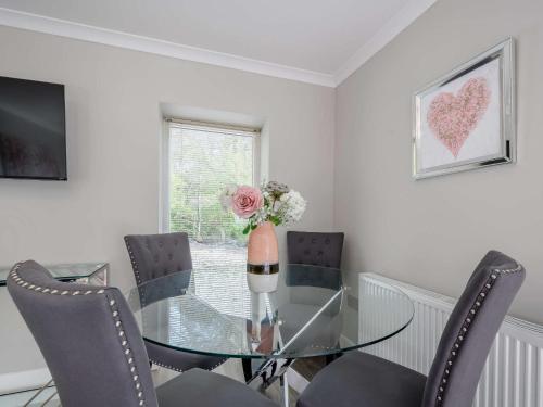 a dining room with a glass table and chairs at 1 Bed in Sandyhills 85904 in Fairgirth