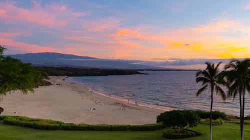 a beach with palm trees and the ocean at sunset at ❤PiH❤Aloha Paradise Large Private Pool Waterfall Spa PLUS 2024 Resort Pool Passes in Waikoloa
