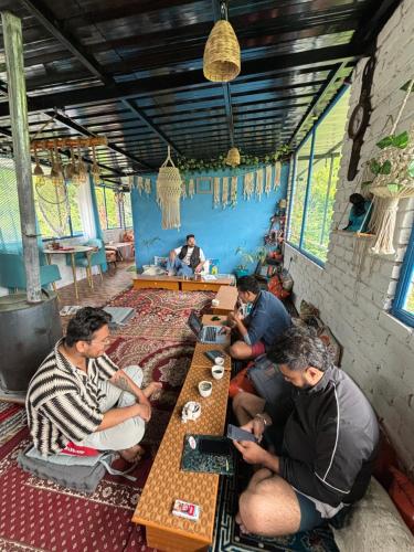 a group of people sitting at tables in a restaurant at Kasolview Homestay and Peace Inn Cafe in Kasol