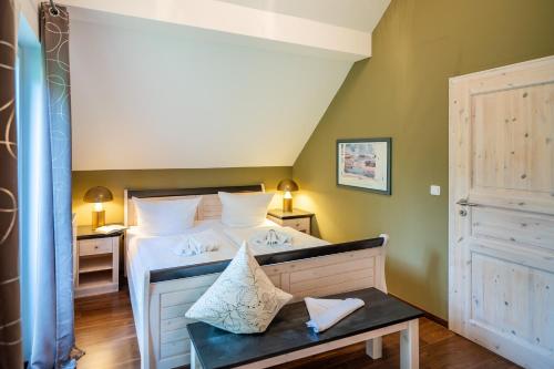 a bedroom with a bed with white sheets and a table at Kuschelige Herbsttage und Meeresrauschen in Breege