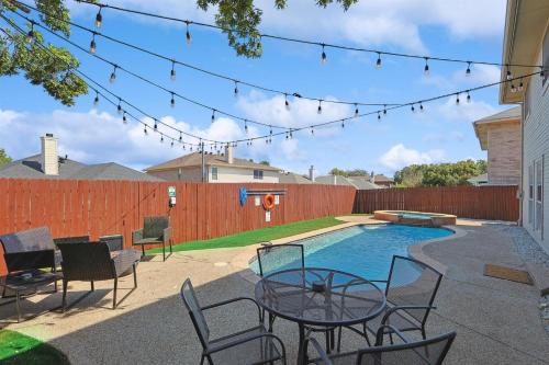 a patio with a table and chairs next to a pool at Modern Comforts & Classic Charm w Pool 5BD in Saginaw