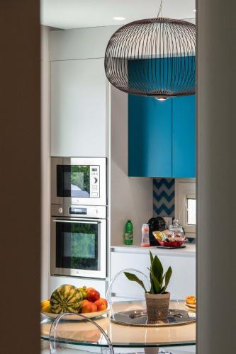 a kitchen with blue cabinets and a plate of fruit at Appartamenti Aurelia 89 in Nardò