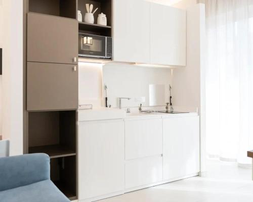 a kitchen with white cabinets and a microwave at Il Mama House in Termoli