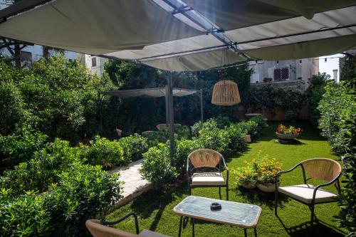 a patio with a table and chairs and an umbrella at Uniconico Trullo & Rooms in Alberobello