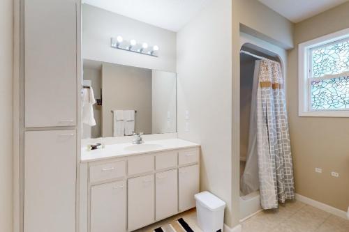 une salle de bain blanche avec un lavabo et un miroir dans l'établissement Lakeside Eden, à Pine Crest