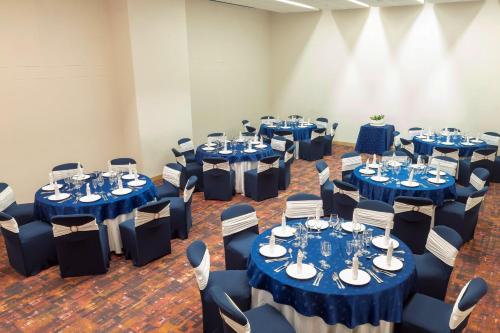 a room filled with tables and chairs with blue linens at Holiday Inn Cúcuta by IHG in Cúcuta