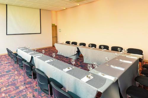 a conference room with tables and chairs and a screen at Holiday Inn Cúcuta by IHG in Cúcuta