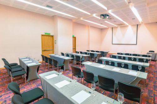 a conference room with tables and chairs and a screen at Holiday Inn Cúcuta by IHG in Cúcuta