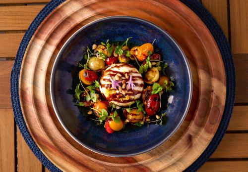 a blue plate of food with vegetables on a table at Shore Hotel in Los Angeles