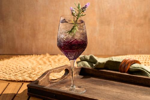 a glass of wine with a flower in it on a tray at Shore Hotel in Los Angeles