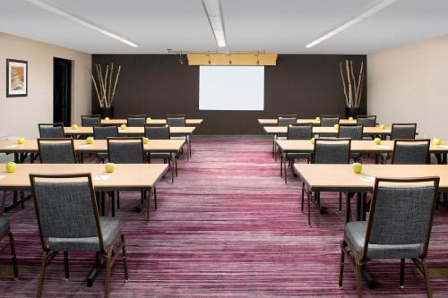 a classroom with tables and chairs and a projection screen at Courtyard by Marriott Portland Hillsboro in Hillsboro