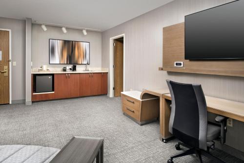 an office with a desk and a flat screen tv at Courtyard by Marriott Portland Hillsboro in Hillsboro