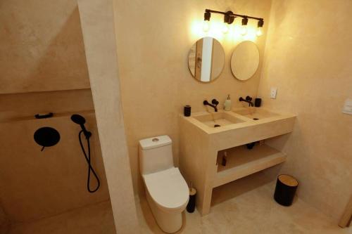 a bathroom with a toilet and a sink and a mirror at Casa Cactus escapada perfecta en Cocoyoc in Cocoyoc