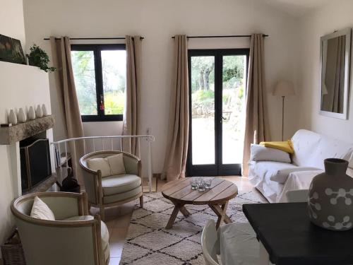 un salon avec un canapé, des chaises et une table dans l'établissement Les Restanques Charmante petite maison nature et calme Grasse, à Grasse