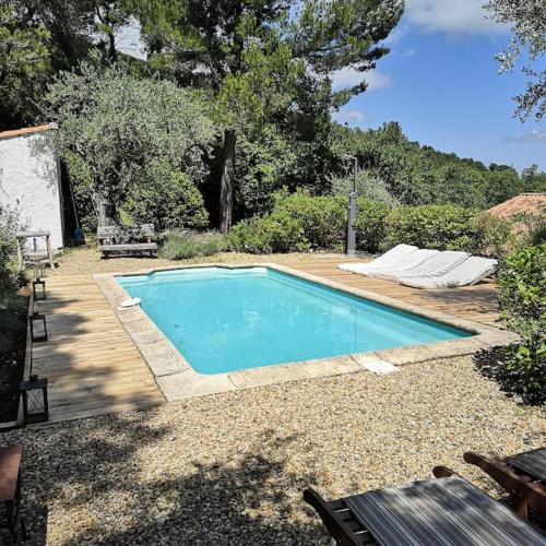 une petite piscine bleue dans une cour dans l'établissement Les Restanques Charmante petite maison nature et calme Grasse, à Grasse