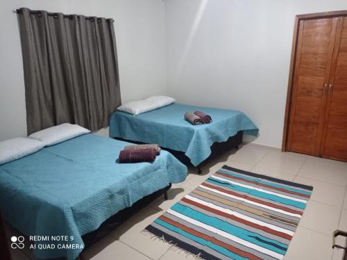 a room with two twin beds and a rug at Casa da Arvore in Mariana