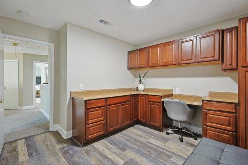 een lege keuken met houten kasten en een stoel bij Modern Comforts & Classic Charm w Pool 5BD in Saginaw