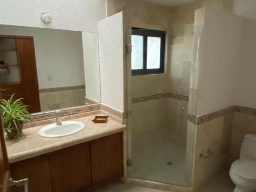 a bathroom with a sink and a shower with a mirror at Casa ideal para familias o grupos in Momoxpan