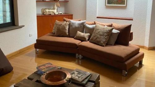 a living room with a brown couch and a table at Casa ideal para familias o grupos in Momoxpan