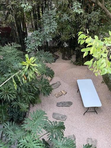 a white bench sitting in the middle of a garden at Casa ideal para familias o grupos in Momoxpan