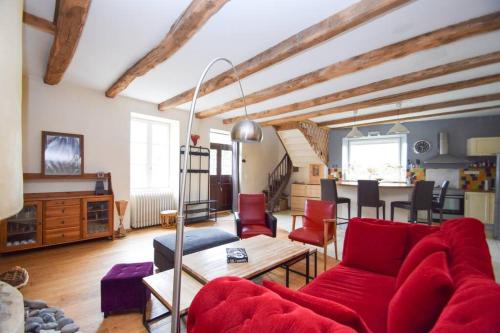 un salon avec un canapé rouge et une table dans l'établissement Maison de bourg Bord de Rance Proximité des plages, à Pleudihen-sur-Rance