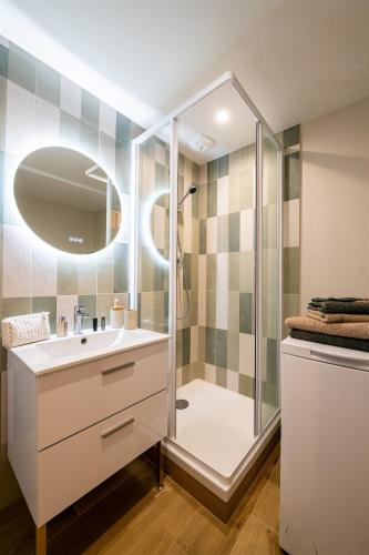 une salle de bain avec une douche, un lavabo et un miroir dans l'établissement Espace, confort, calme et design en plein centre !, à Laval