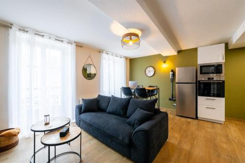 un salon avec un canapé et une cuisine dans l'établissement Espace, confort, calme et design en plein centre !, à Laval