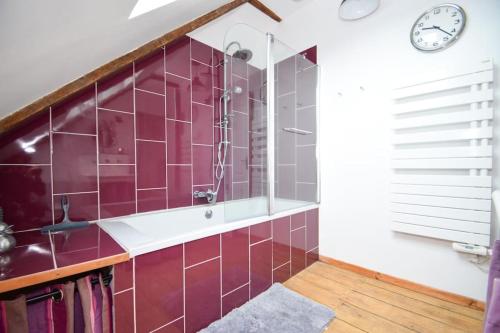 La salle de bains est pourvue d'une douche et d'une horloge murale. dans l'établissement Maison de bourg Bord de Rance Proximité des plages, à Pleudihen-sur-Rance