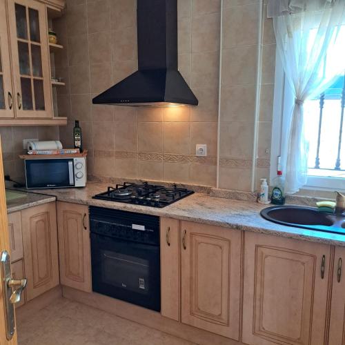 a kitchen with a stove top oven next to a sink at Chamarin in Arboleas