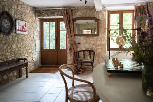 a room with a table and chairs and a door at Charming La Maison Des Artistes near Bergerac with the Swimming Pool in Conne-de-Labarde
