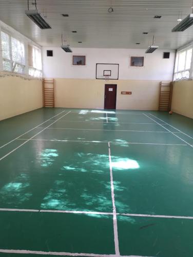 an empty gymnasium with a green basketball court at Horský Hotel Magura in Chvojnica