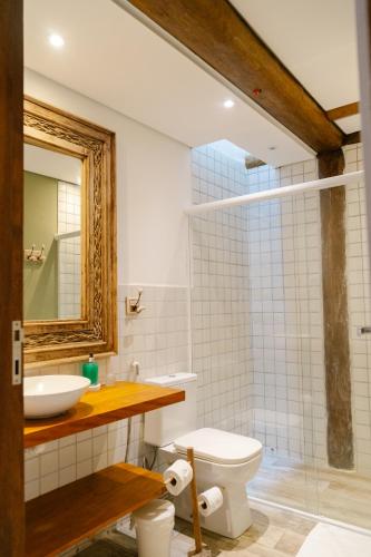 a bathroom with a sink and a toilet and a mirror at Casa Formosa Baleia in São Sebastião