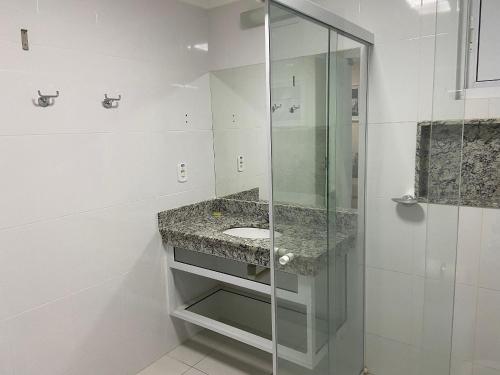 a bathroom with a sink and a glass shower at Hotel Piazza diRoma com acesso ao Acqua Park e Splash in Caldas Novas