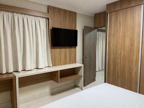 a hotel room with a television and a room at Hotel Piazza diRoma com acesso ao Acqua Park e Splash in Caldas Novas