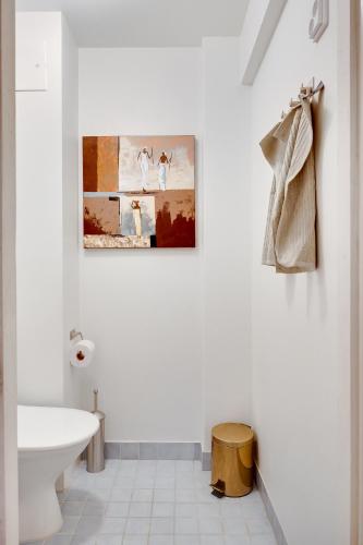 a bathroom with a white toilet and a picture on the wall at Rent a box Turku City Center in Turku