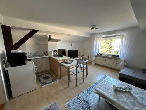 a kitchen and living room with a table and a refrigerator at Ferienwohnung im Deister in Springe