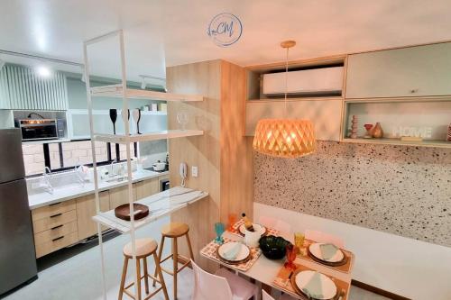 a kitchen with a table and some chairs and a refrigerator at Flat Patacho - Rota Ecológica dos Milagres in Pôrto de Pedras