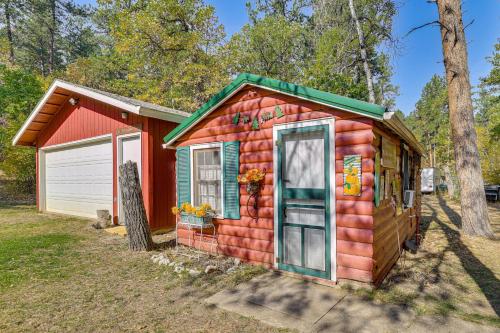 a small red house with a garage at Historic Keystone Cabin Near Mount Rushmore! in Keystone