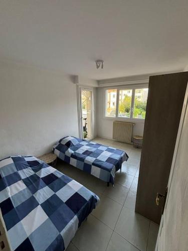 une chambre avec deux lits et une fenêtre dans l'établissement Appartement T3 Cagnes sur Mer, à Cagnes-sur-Mer