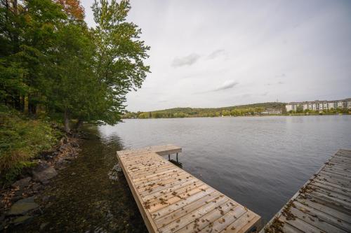 a dock on a lake with a building in the background at MuskokaWaterfront PoolTable 98TV 6Acres in Huntsville