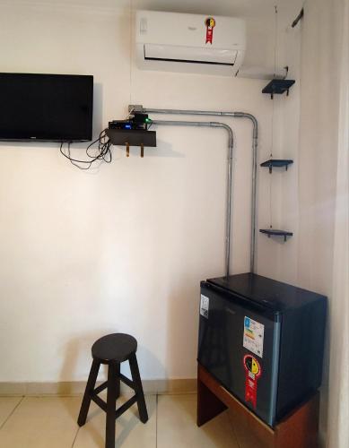 a room with a stool next to a television and a stool at Micasa Hostel - Congonhas in Sao Paulo