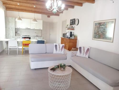 uma sala de estar com dois sofás brancos e uma mesa em Ciuri CiuriHome em Balestrate