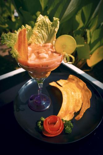 a drink on a blue plate with lettuce and a salad at Dharma Hotel Boutique Spa in San Jerónimo
